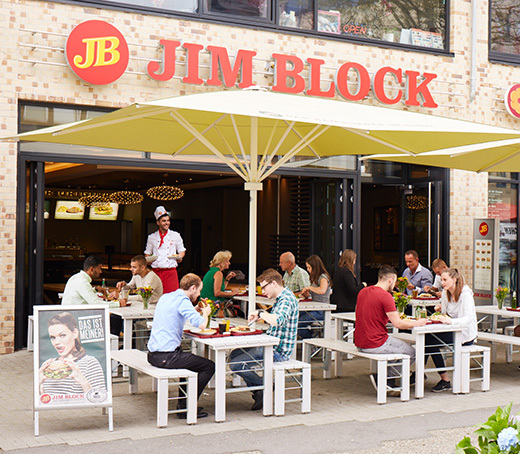 Jim Block Altona Restaurant Außenbereich Außenbereich des Jim Block Restaurants in Altona mit Gästen unter großen Sonnenschirmen.
