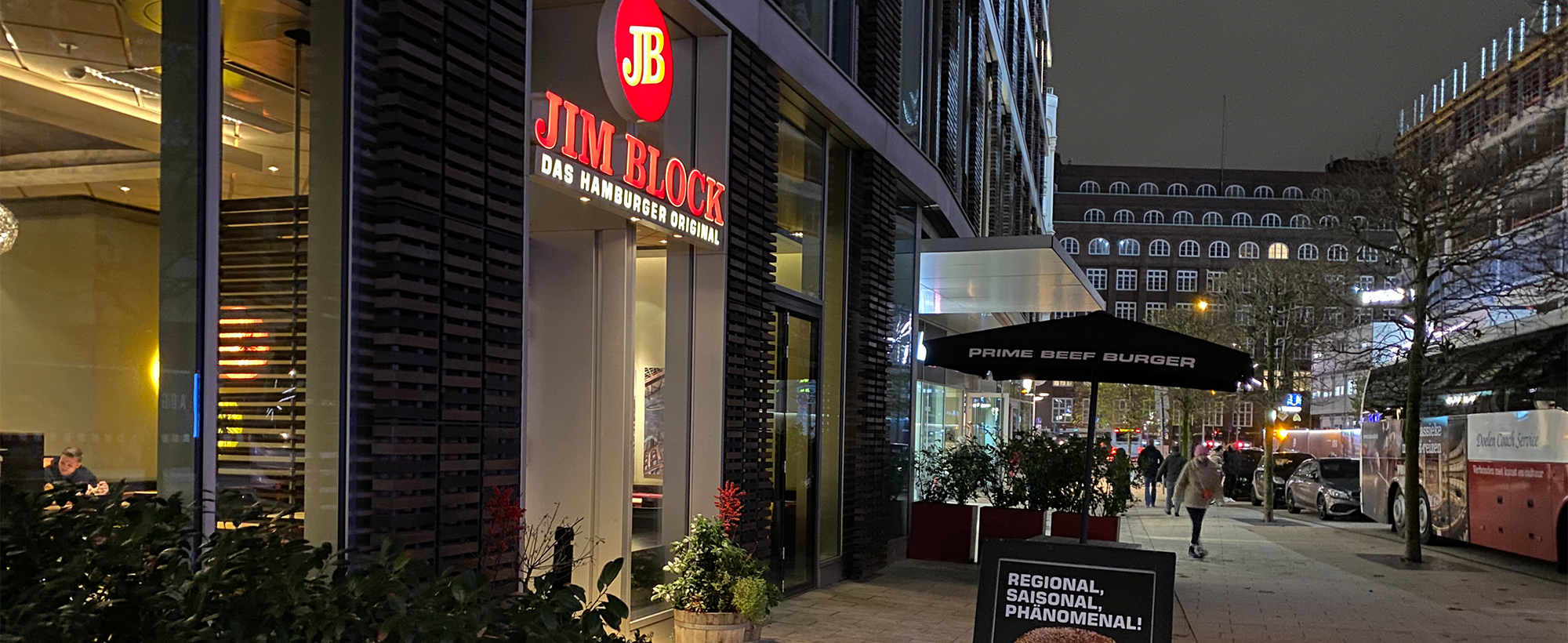 Außenansicht des Jim Block Restaurants am Dammtor bei Nacht Außenansicht des Jim Block Restaurants am Dammtor bei Nacht, mit leuchtendem Logo und Straßenbeleuchtung.