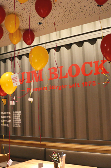 Eröffnung des Jim Block Rostock Rotes und gelbes Luftballon-Dekor schwebt unter der Decke im neuen Jim Block Restaurant Rostock – feierliche Eröffnung im modernen, urbanen Stil.